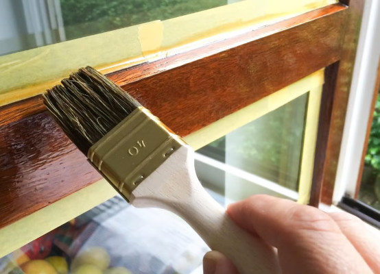 Holzfenster wird lackiert mit braunem Lack